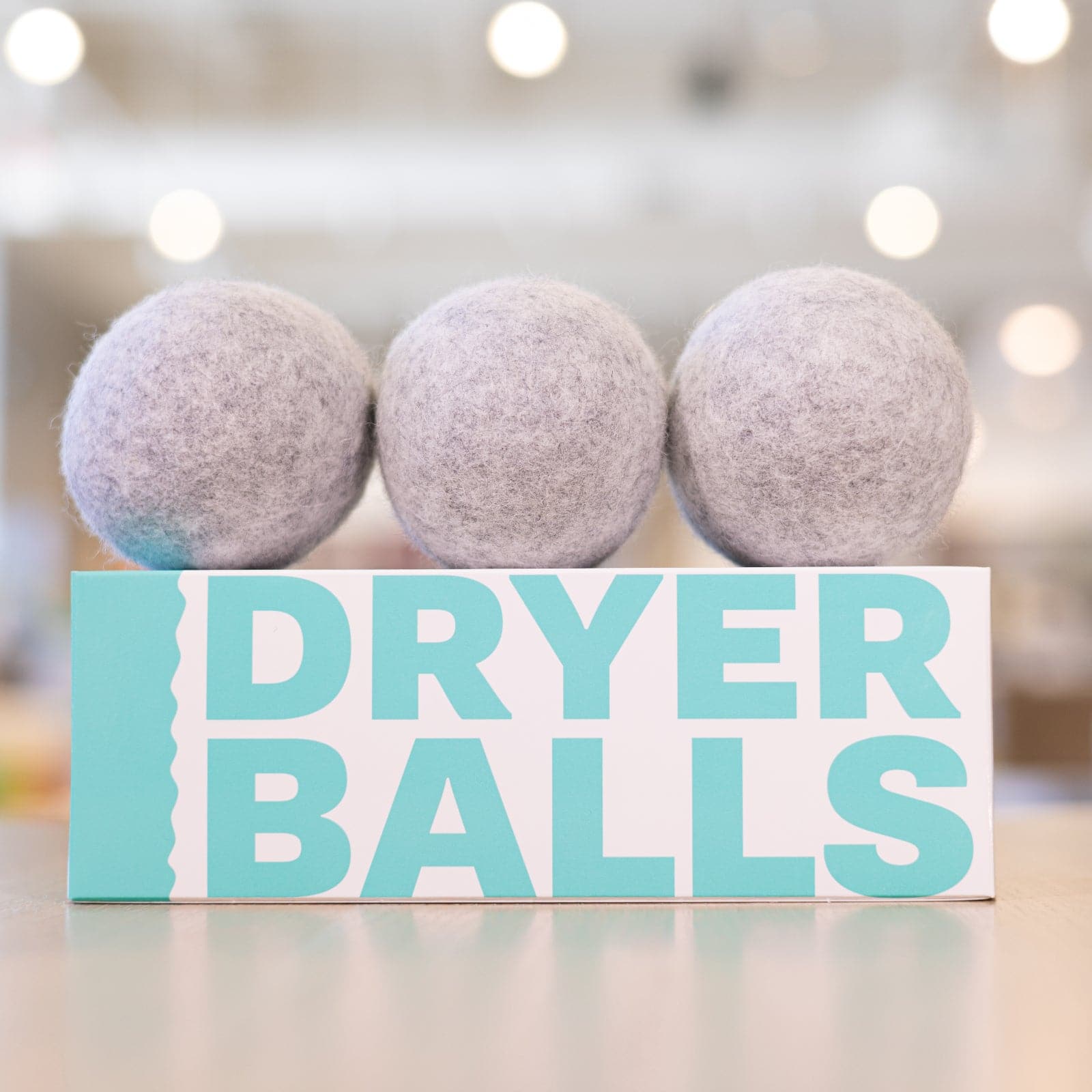 Three Buff City Soap Dryer Balls stacked in a row on top of packaging