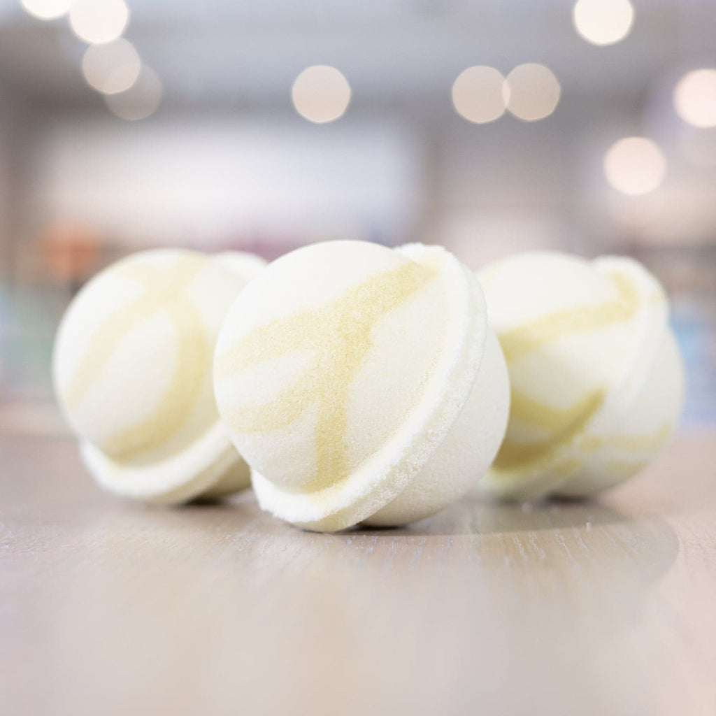Three Good Morning Sunshine Bath Bombs with light yellow design lined up on counter 