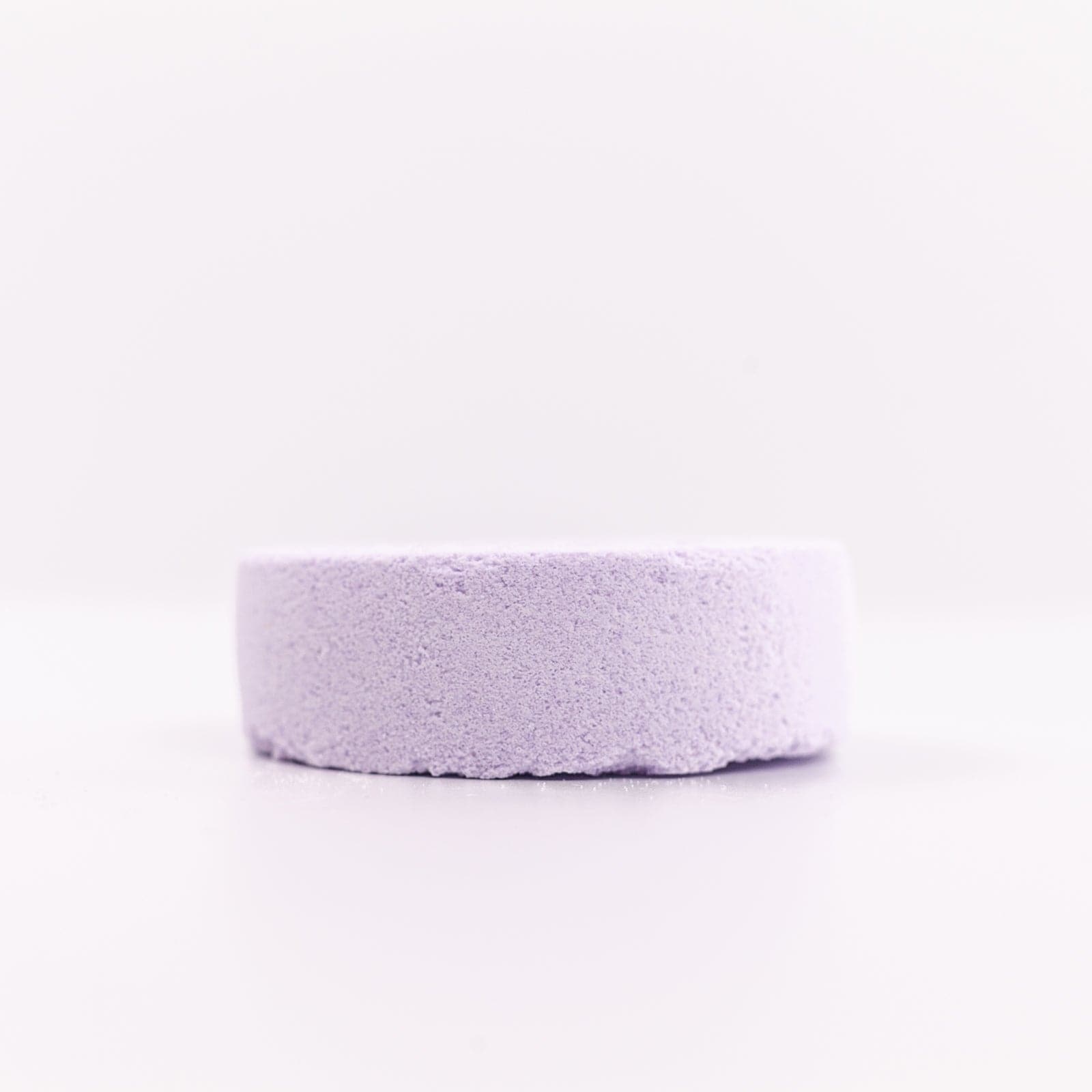 Buff City Soap's lavender colored and scented shower fizzy soap faced down