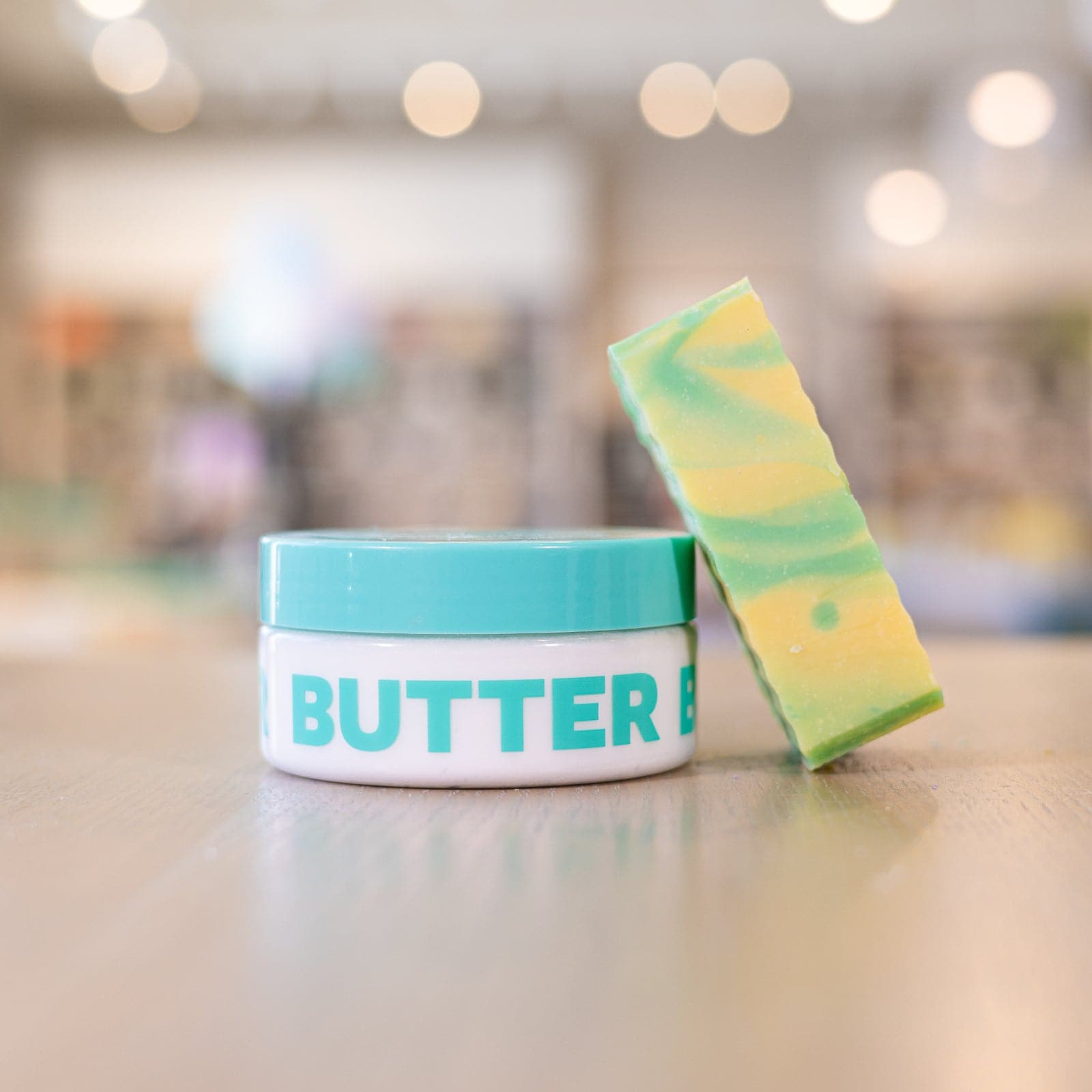 Buff City Soap's lemongrass and eucalyptus scented body butter with a soap bar angled against it