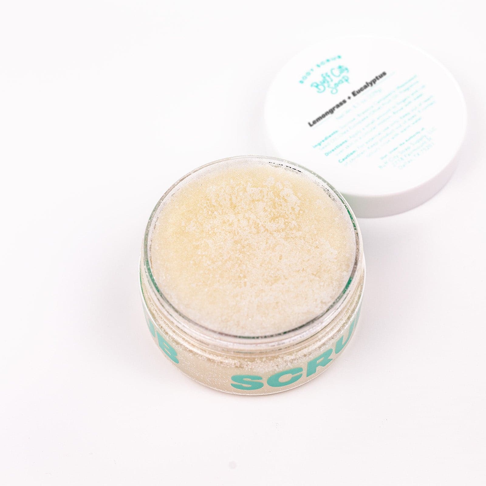 Buff City Soap's lemongrass + eucalyptus scented body scrub can open with the lid next to it