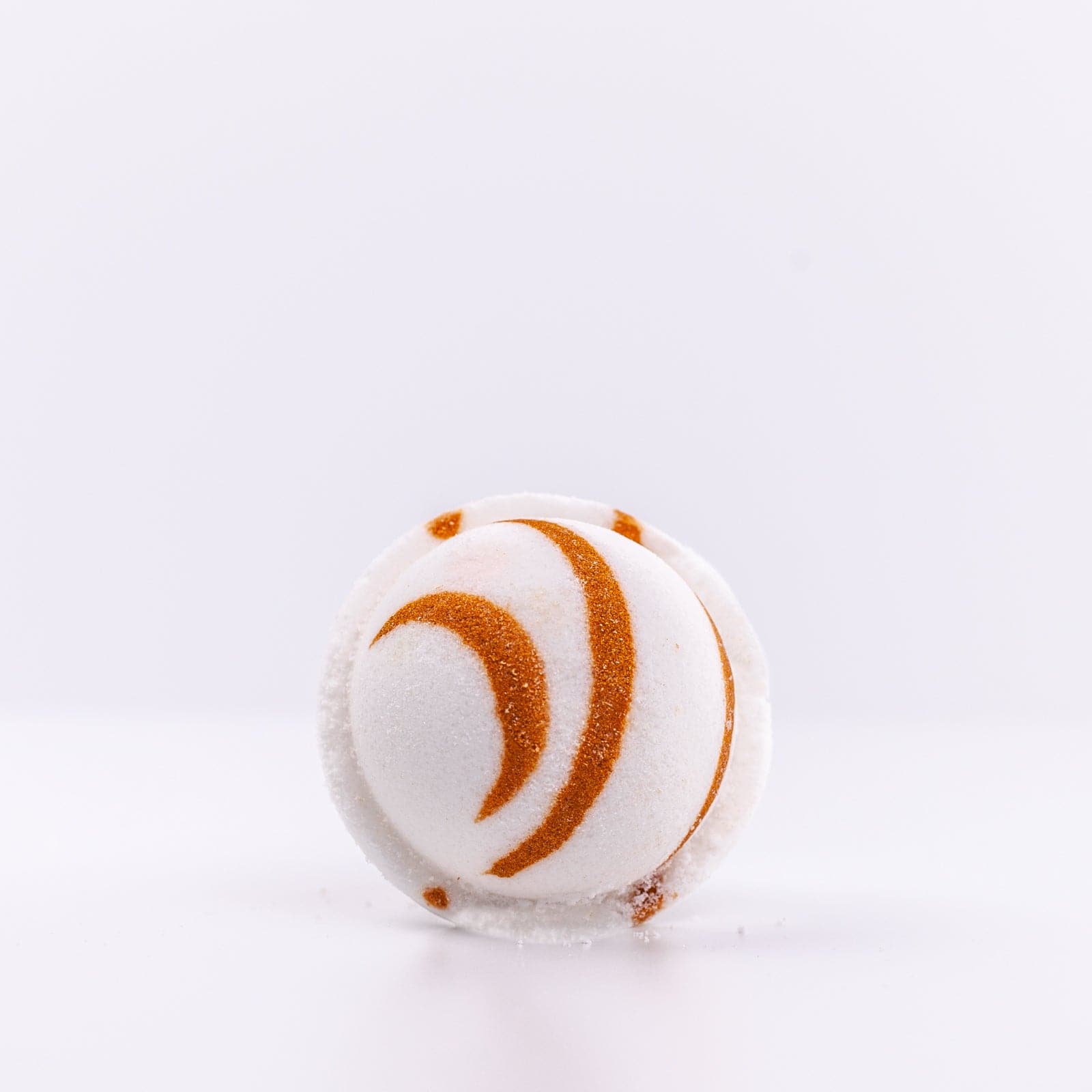 top view of white Narcissist Bath Bomb with dark orange design