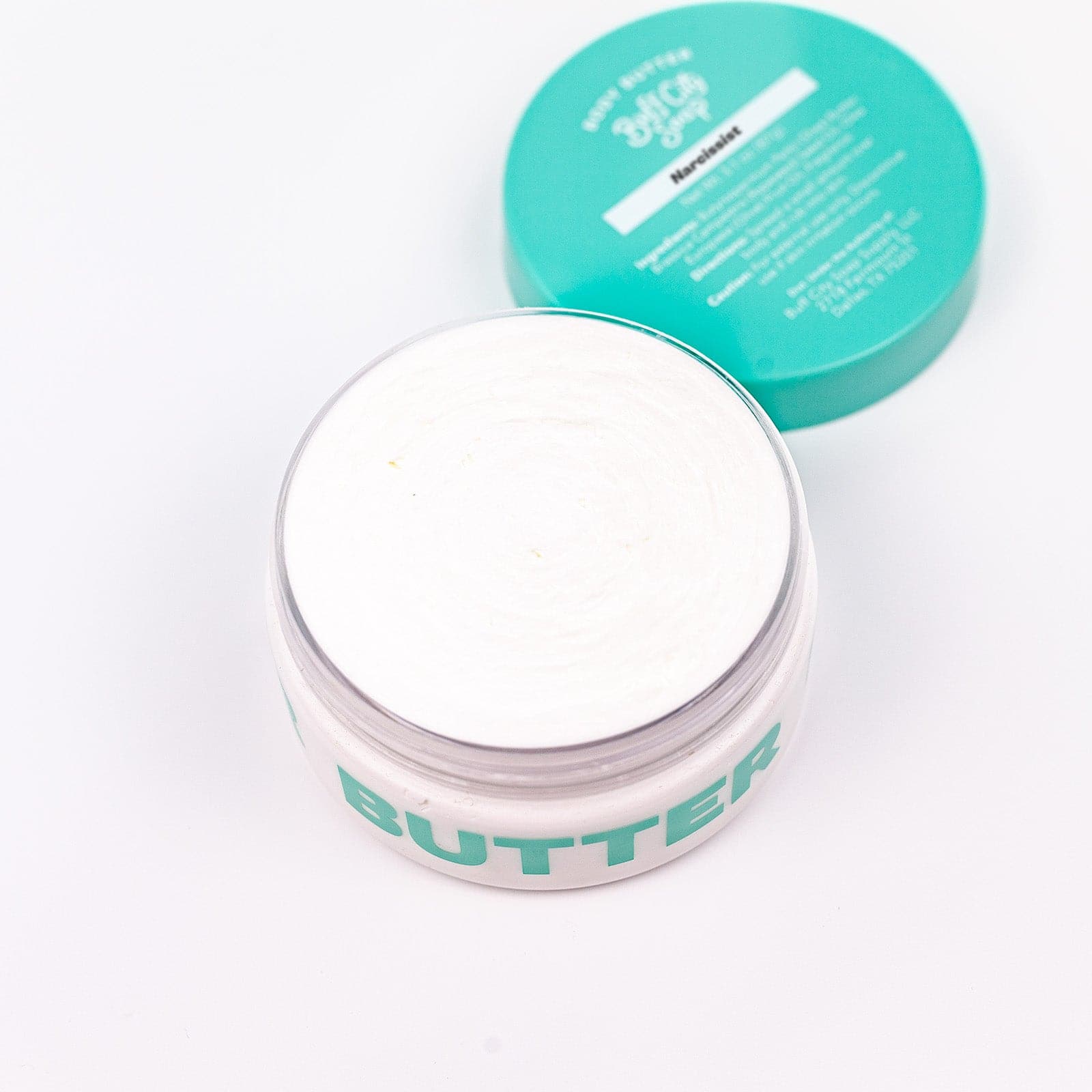 open container of Narcissist Body Butter with lid placed behind container