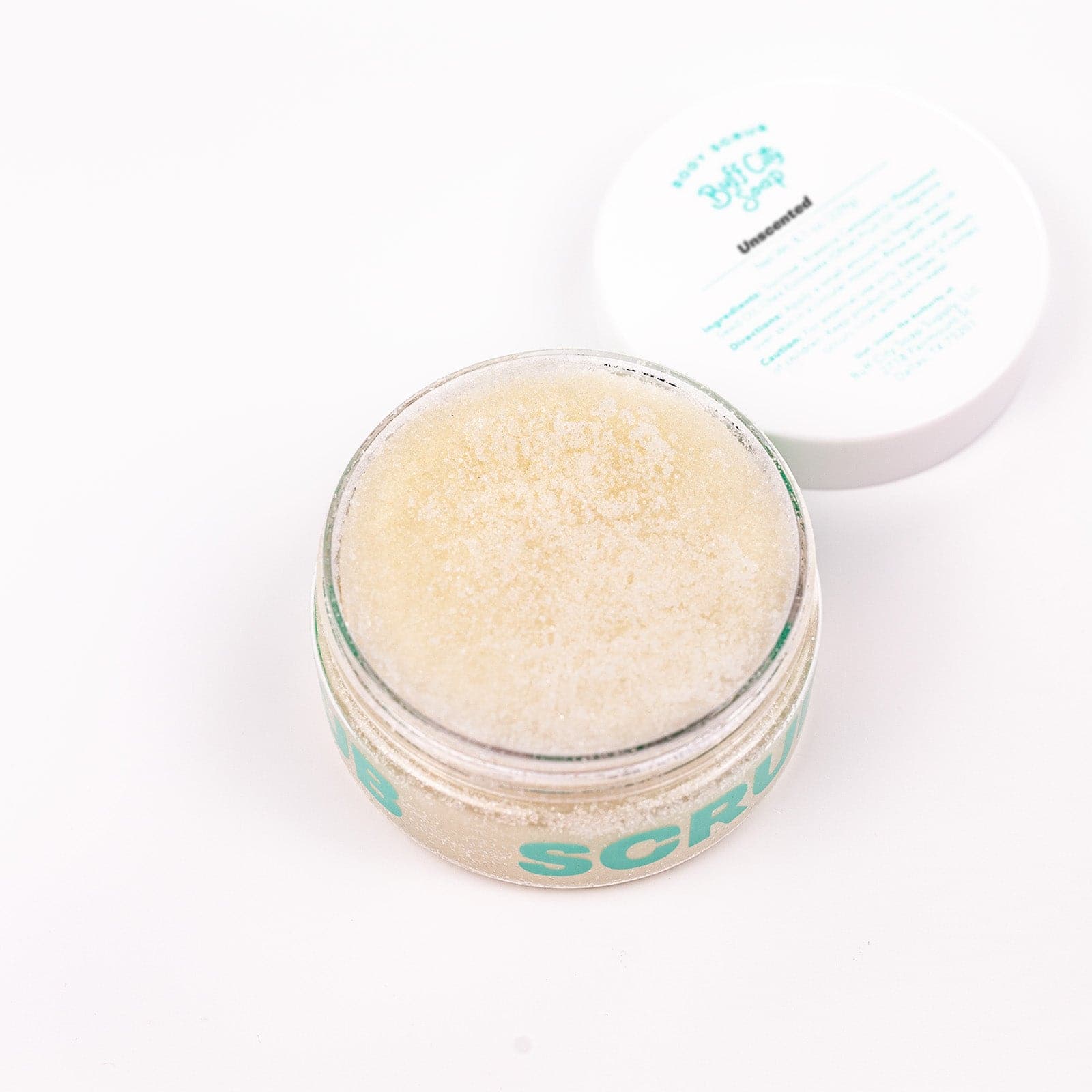 Open jar of Unscented Body Scrub with lid placed next to it